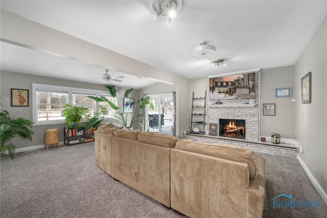 living room with a fireplace, plenty of natural light, and carpet floors