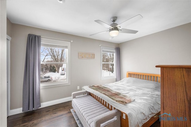 bedroom with dark hardwood / wood-style flooring and ceiling fan