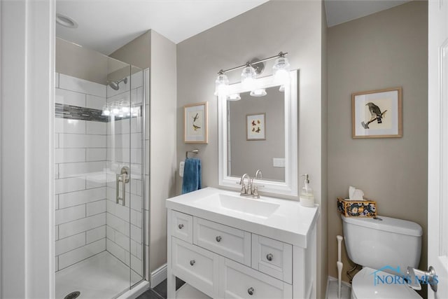 bathroom with vanity, toilet, and a shower with door