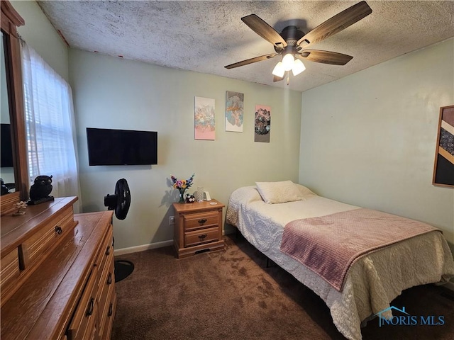 bedroom with dark carpet, ceiling fan, and a textured ceiling