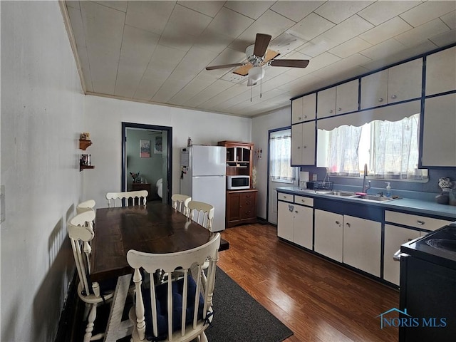 kitchen with sink, dark wood-type flooring, white appliances, and white cabinets