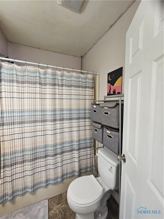 bathroom featuring shower / bathtub combination with curtain and toilet