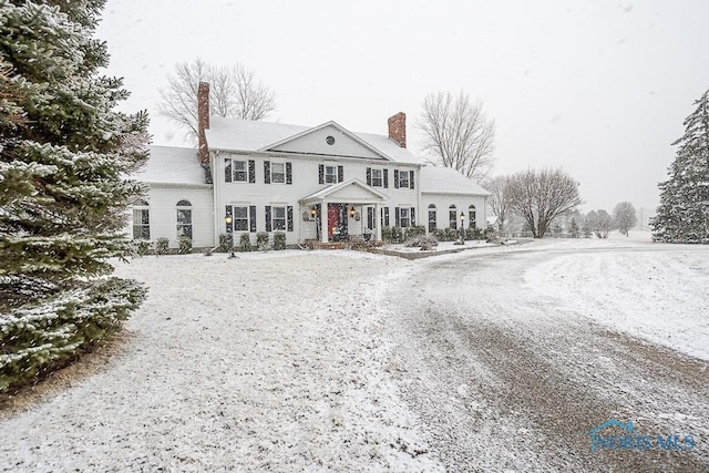 view of front of house with gravel driveway and a chimney