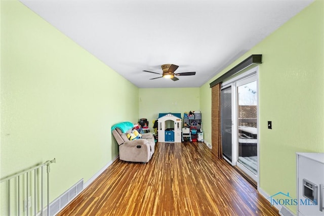 game room with visible vents, wood finished floors, a ceiling fan, and baseboards