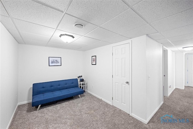 sitting room featuring a drop ceiling, carpet flooring, and baseboards