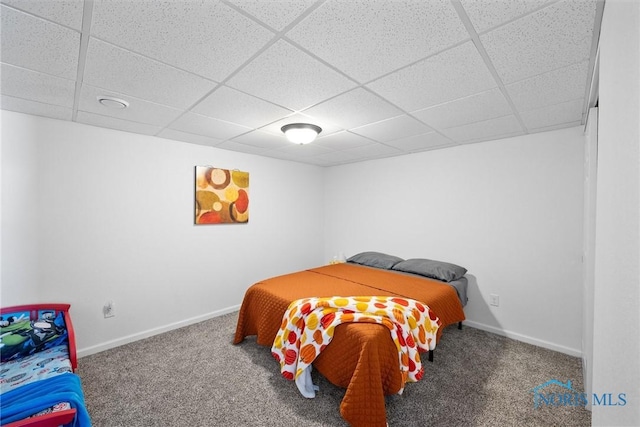 bedroom with a paneled ceiling, baseboards, and carpet flooring