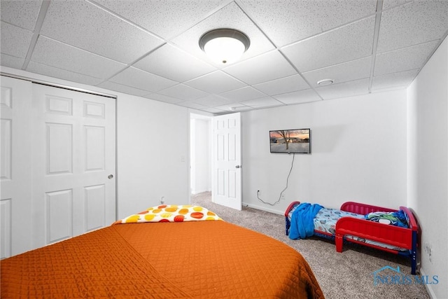 unfurnished bedroom with carpet floors, baseboards, and a drop ceiling