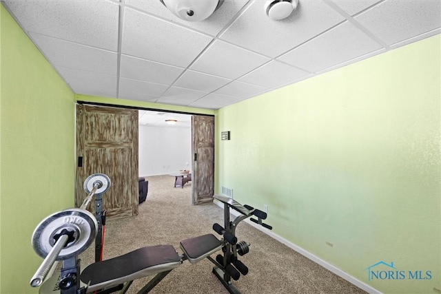 exercise area featuring a drop ceiling, carpet flooring, visible vents, and baseboards