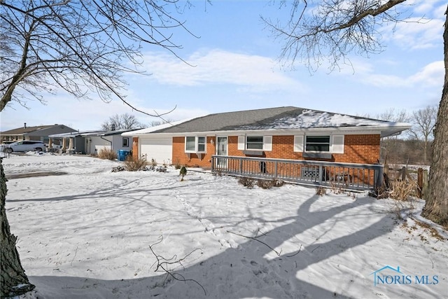 snow covered house with brick siding and an attached garage