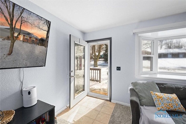 doorway to outside featuring light tile patterned floors and baseboards