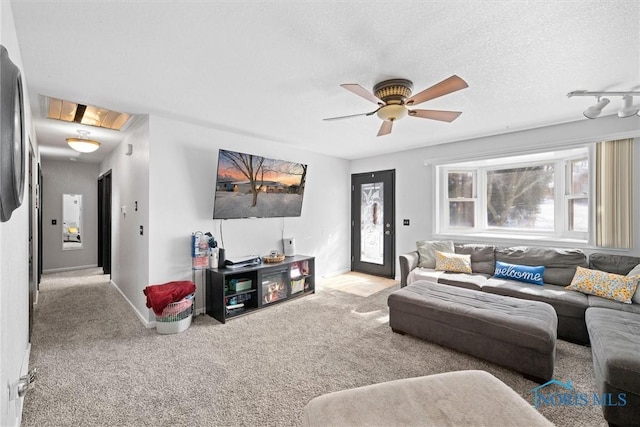 living room featuring a textured ceiling, carpet floors, and ceiling fan