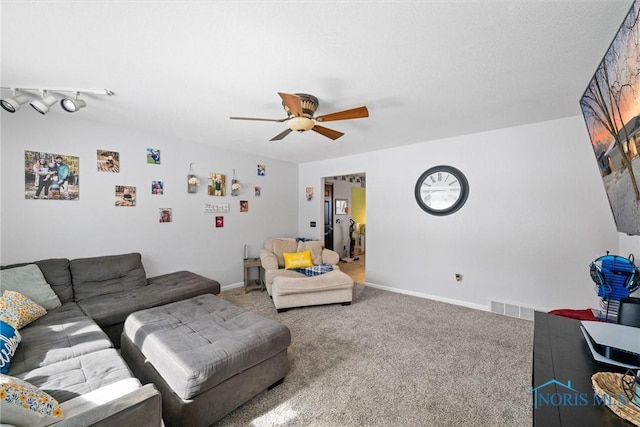 living room with baseboards, carpet, visible vents, and a ceiling fan