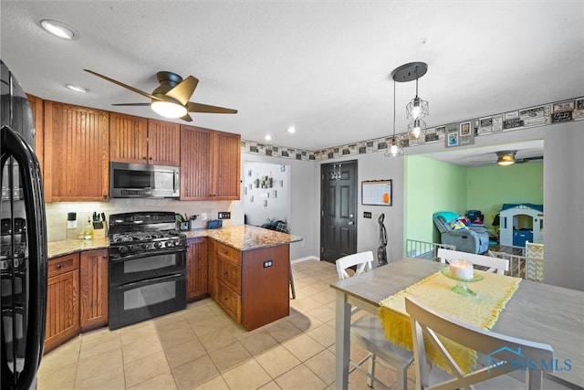 kitchen featuring decorative backsplash, brown cabinetry, light stone counters, a peninsula, and black appliances