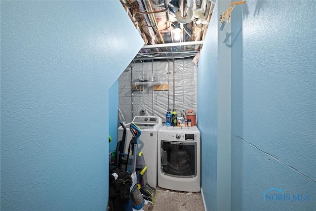 washroom featuring washer and dryer and a textured wall