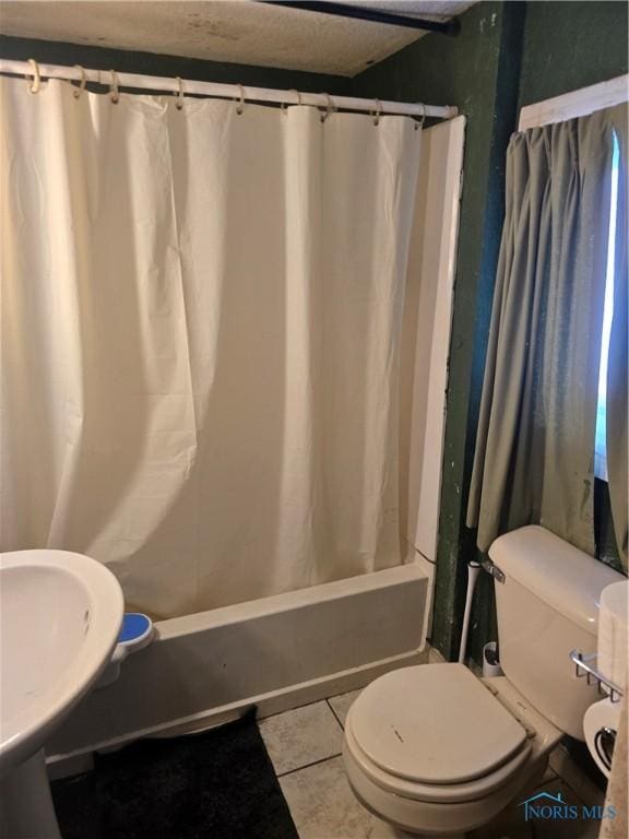 full bath featuring shower / bath combo, tile patterned flooring, and toilet