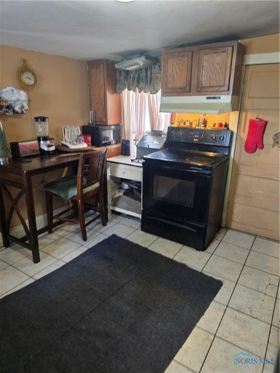 kitchen featuring brown cabinets, light tile patterned floors, tile counters, under cabinet range hood, and black appliances