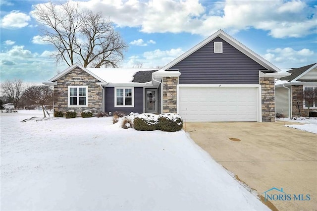 ranch-style home featuring driveway, stone siding, and an attached garage