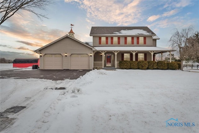 view of front of home featuring a garage, covered porch, and driveway