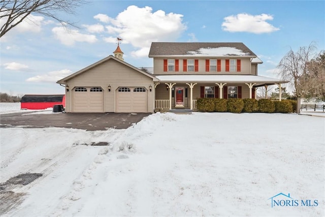 view of front of house with aphalt driveway, covered porch, and an attached garage