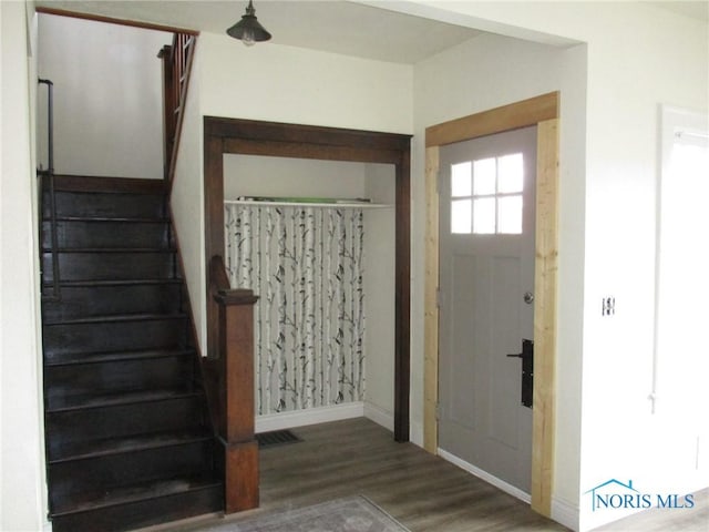 entrance foyer with stairway, wood finished floors, and baseboards