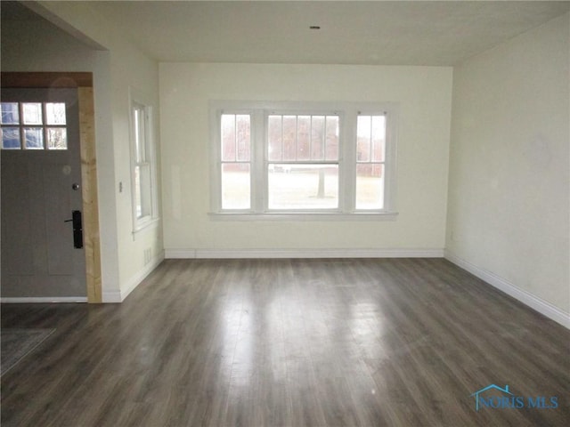 interior space with baseboards and dark wood-style flooring