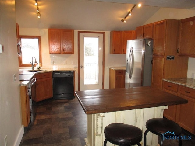 kitchen with decorative backsplash, brown cabinetry, appliances with stainless steel finishes, a breakfast bar, and a sink