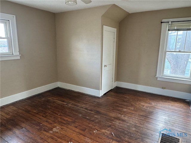 interior space featuring plenty of natural light, baseboards, and dark wood-style flooring