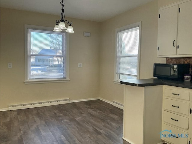 kitchen featuring baseboard heating, decorative light fixtures, dark wood-type flooring, and white cabinetry