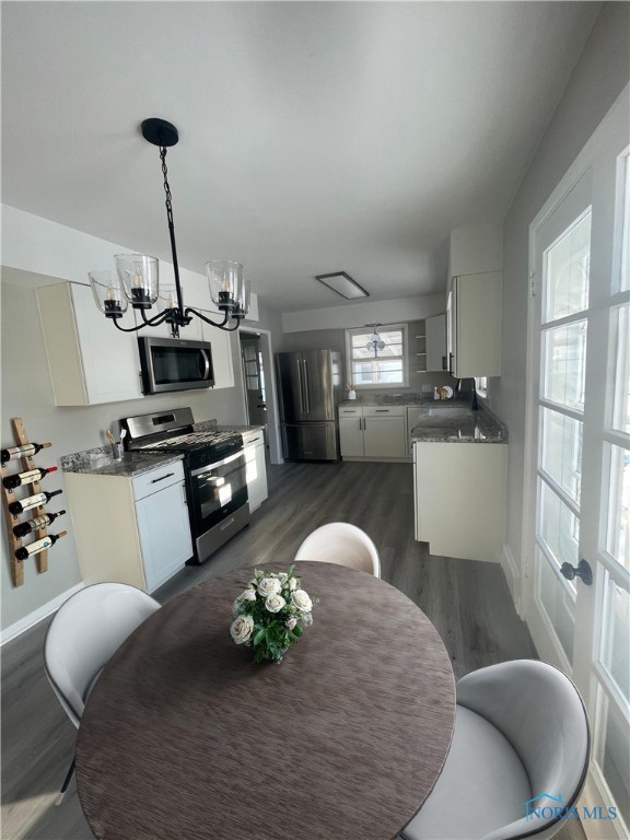 dining room with dark wood-type flooring and a notable chandelier