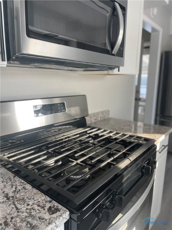 interior details with stainless steel appliances and light stone countertops