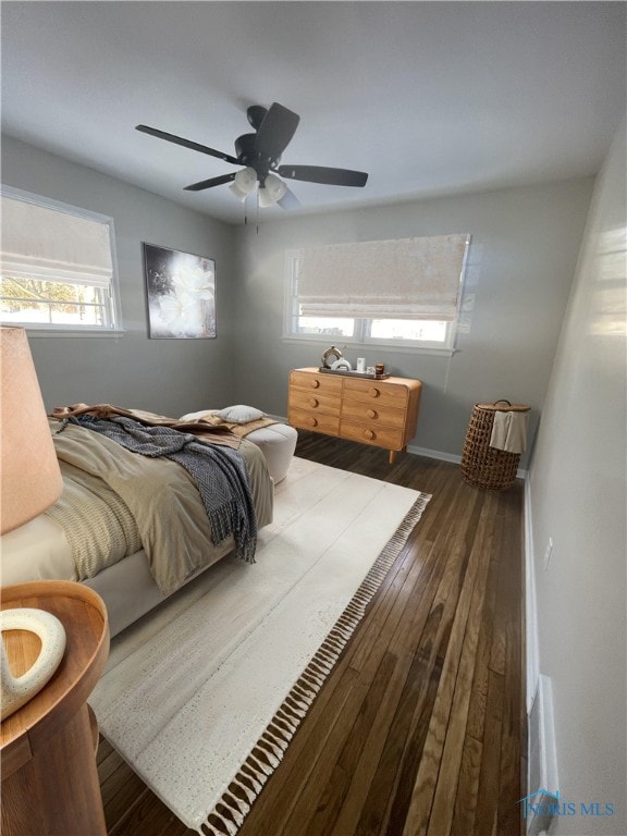 bedroom featuring multiple windows, ceiling fan, and dark hardwood / wood-style floors