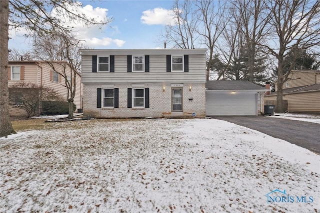 view of front of home with a garage, driveway, and brick siding