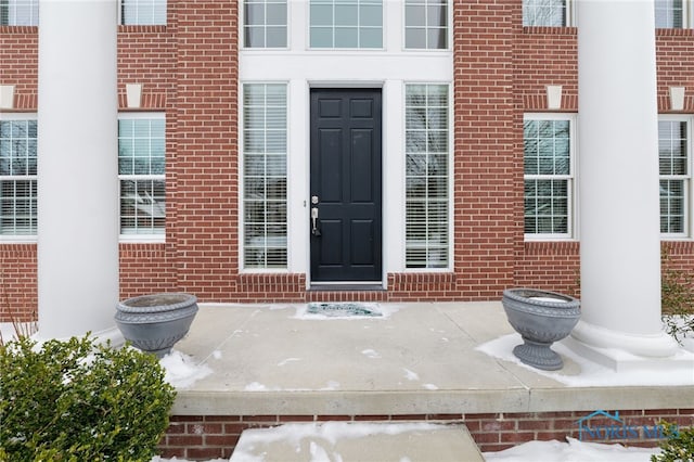 view of exterior entry with brick siding