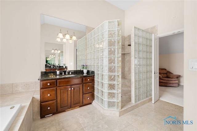 full bathroom featuring tile patterned flooring, vanity, vaulted ceiling, a walk in shower, and a garden tub