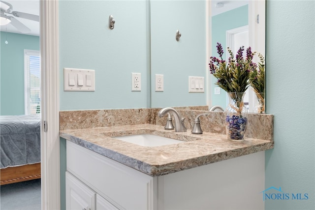 ensuite bathroom featuring ceiling fan, ensuite bath, and vanity