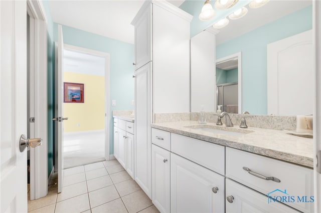 bathroom with baseboards, tile patterned flooring, and vanity