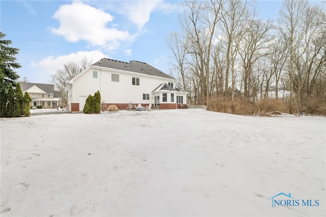 view of snow covered back of property