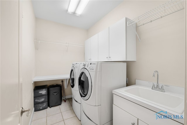 laundry area featuring cabinet space, light tile patterned floors, independent washer and dryer, and a sink