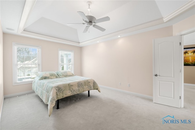 bedroom featuring light carpet, baseboards, and a tray ceiling