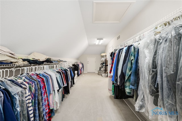 spacious closet featuring carpet flooring, vaulted ceiling, attic access, and visible vents