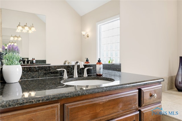 bathroom featuring lofted ceiling and vanity