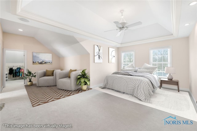 bedroom with light carpet, baseboards, a ceiling fan, and a tray ceiling