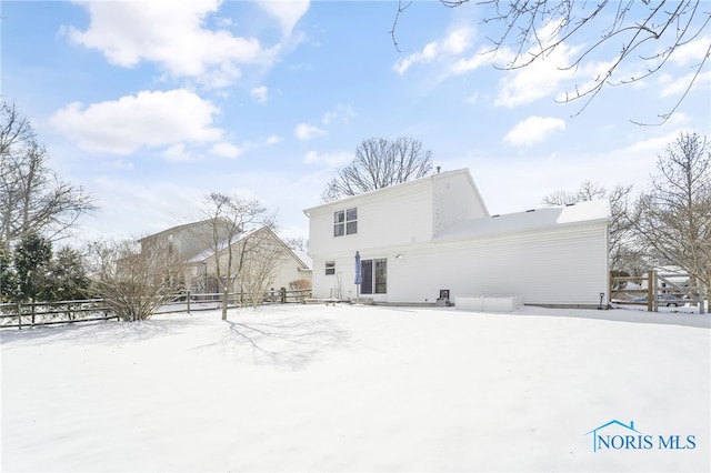 snow covered back of property with fence