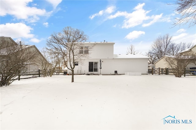 snow covered back of property with fence