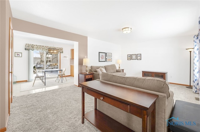 living room featuring light carpet and baseboards