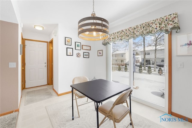 dining room with a notable chandelier, baseboards, and light tile patterned floors