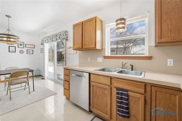 kitchen with hanging light fixtures, dishwasher, light countertops, and a sink