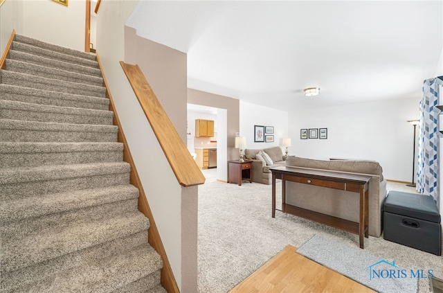 stairs featuring baseboards and carpet