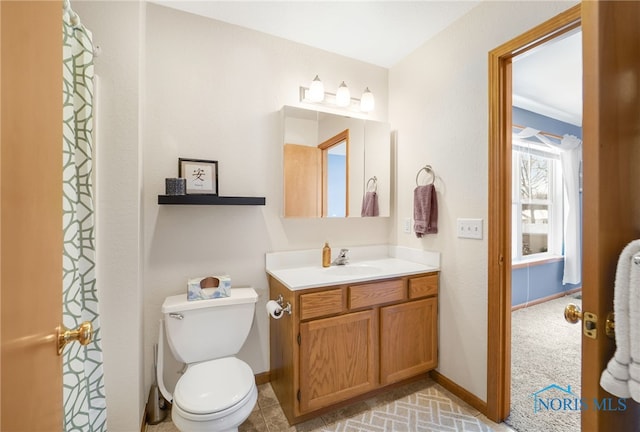 full bathroom with baseboards, toilet, and vanity