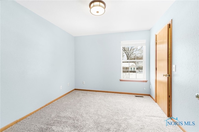 carpeted empty room with baseboards and visible vents